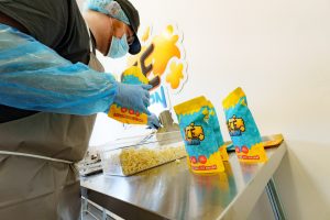 Production Assistant pouring popcorn into bags