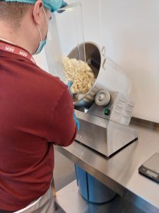 Marketing Apprentice pouring popcorn into mixer