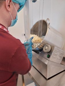 Marketing Apprentice pouring popcorn into mixer