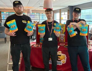 Production Assistants standing in front of table holding popcorn bags