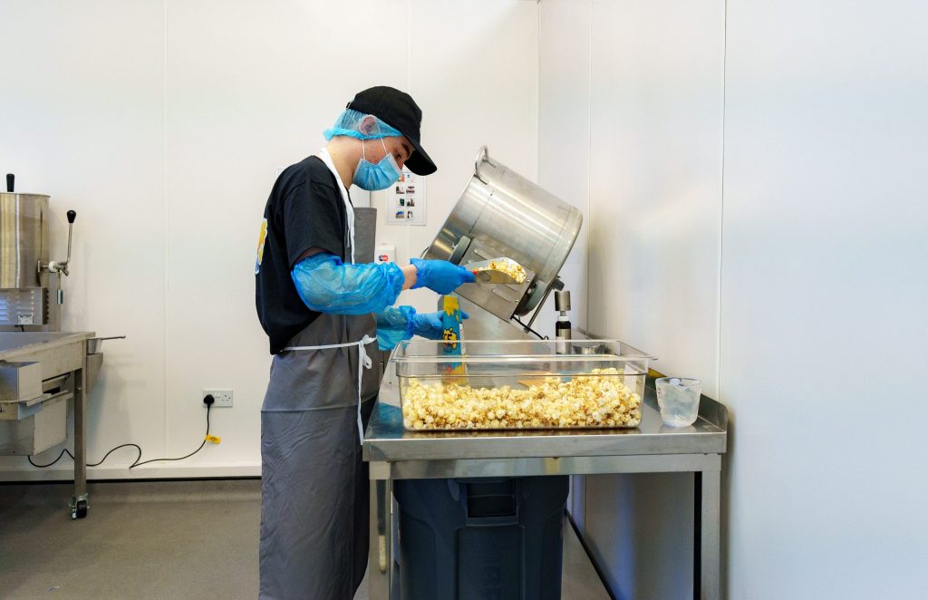 Production Assistant pouring popcorn into bag