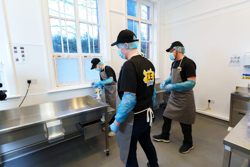 Three Production Assistants cleaning equipment