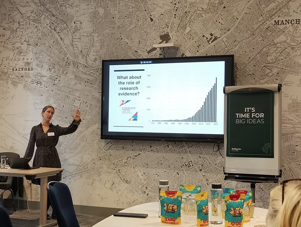 Member of the Autism Alliance giving presentation with ACE Popcorn in foreground
